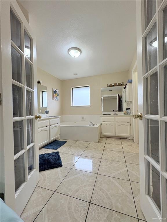 2218 Lawndale Road Mission, TX 78572 - Photo 10 of 24 Full bath featuring a bath, two vanities, a textured ceiling, and a sink
