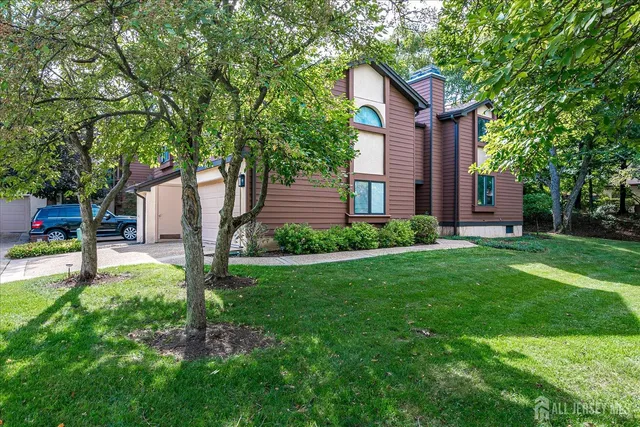 a view of a house with backyard and a tree