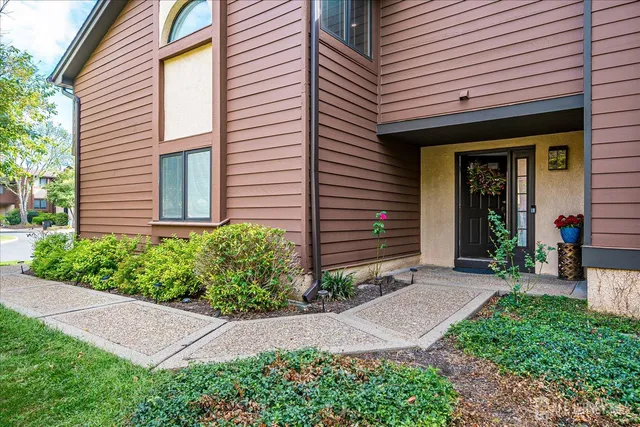 a front view of a house with a yard and potted plants