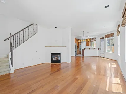 a view of empty room with wooden floor and fireplace