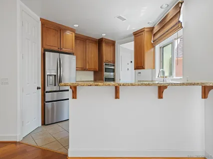a kitchen with stainless steel appliances granite countertop a refrigerator and a sink