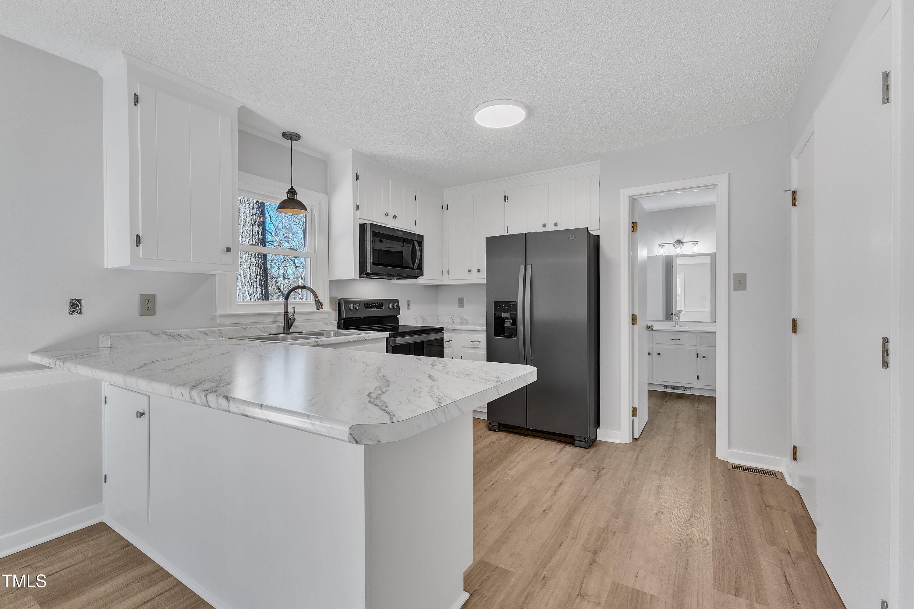 612 Miller Road Hillsborough, NC 27278 - Photo 11 of 35 a kitchen with a sink a refrigerator a microwave and cabinets