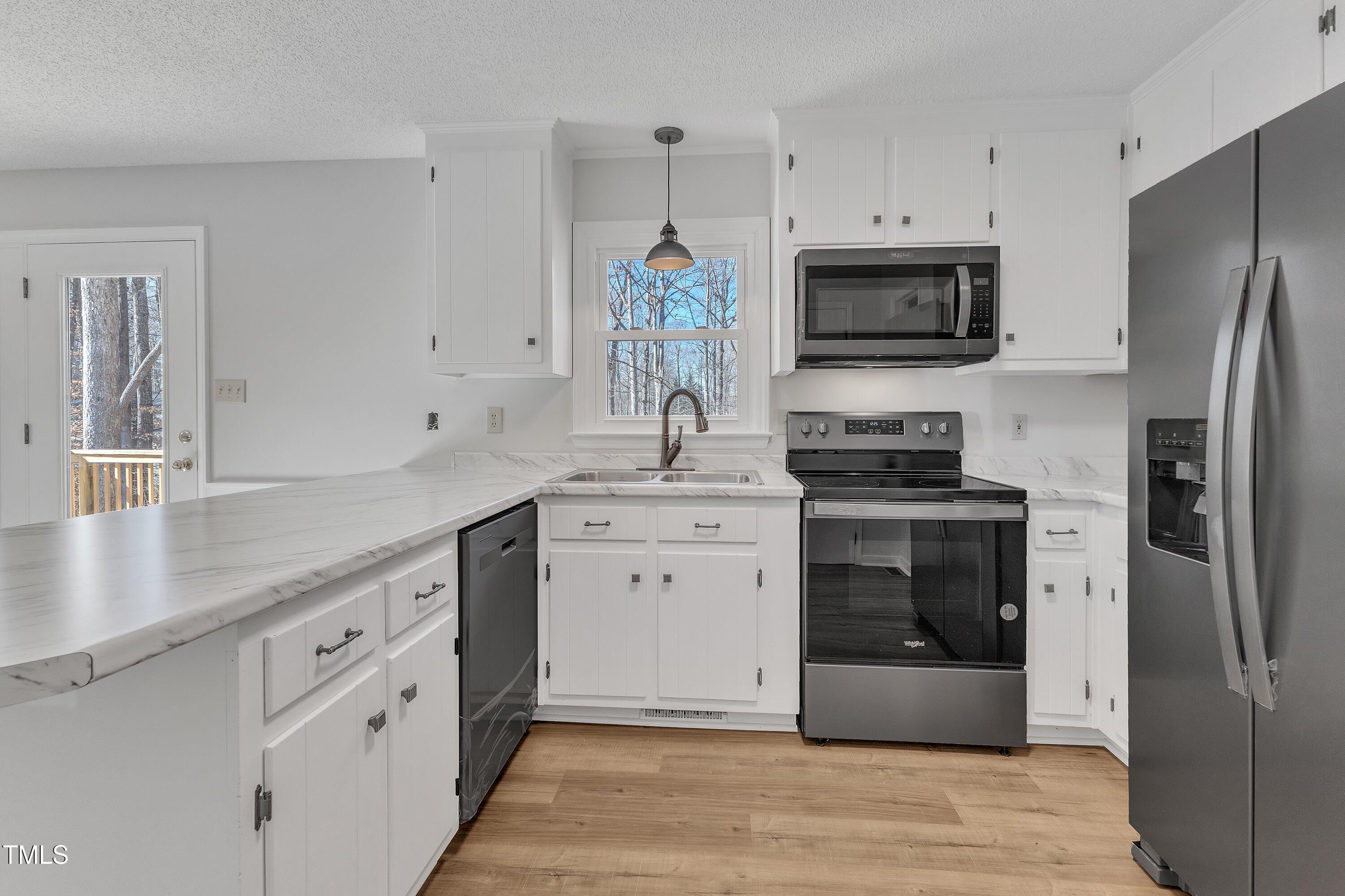 612 Miller Road Hillsborough, NC 27278 - Photo 12 of 35 a kitchen with white cabinets stainless steel appliances and a sink