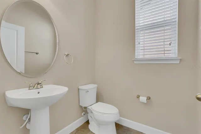 a bathroom with a sink a toilet and mirror
