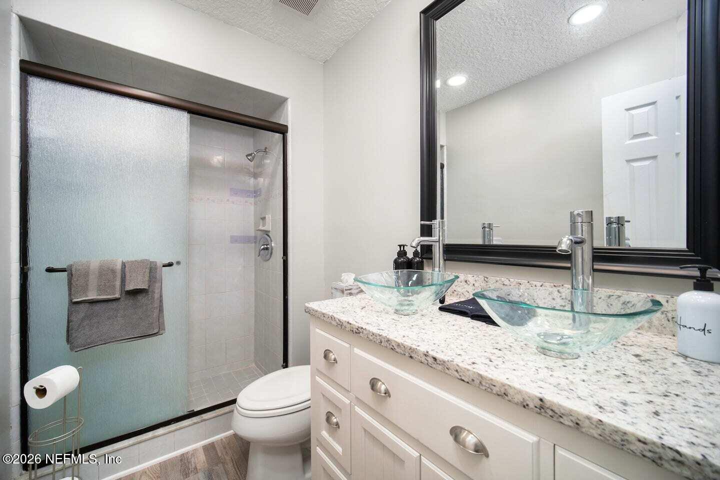 11613 Lake Ride Drive Jacksonville, FL 32223 - Photo 29 of 42 a bathroom with a granite countertop sink a toilet and a mirror