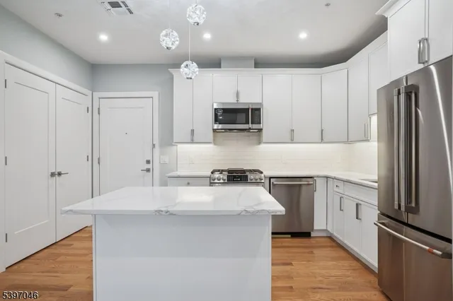a kitchen with stainless steel appliances granite countertop a stove a sink and a refrigerator