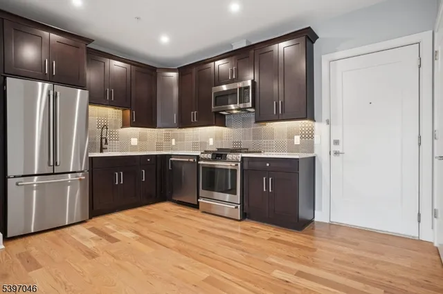 a kitchen with stainless steel appliances granite countertop a refrigerator stove and sink
