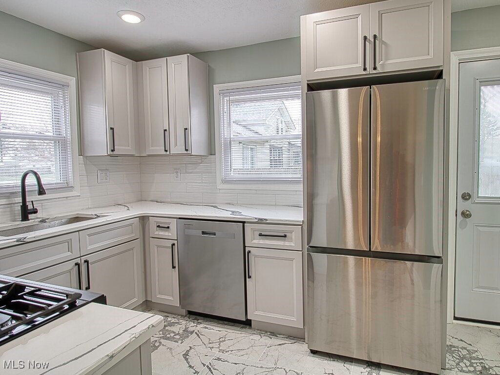 5840 Pearl Road Cleveland, OH 44130 - Photo 12 of 39 Kitchen with sleek finishes, stone counters, 2025 stainless steel appliances, tile flooring.