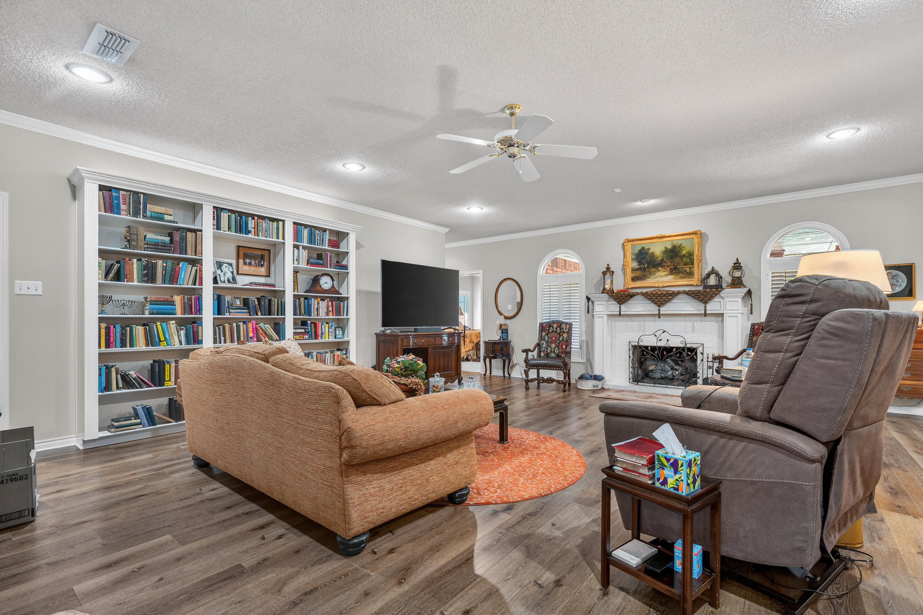 7402 95th Street Lubbock, TX 79424 - Photo 10 of 43 a living room with furniture a flat screen tv and a fireplace