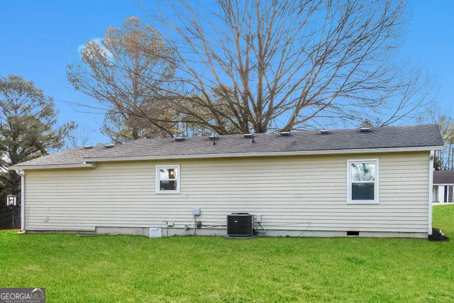 a view of a backyard with plants and large tree