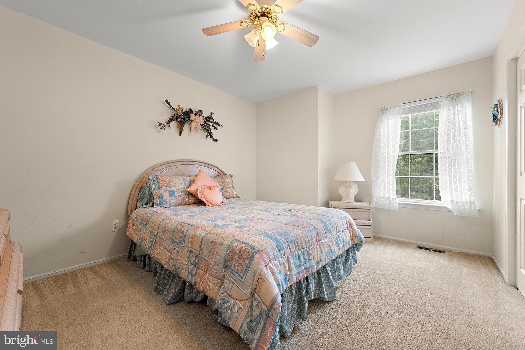 249 Topside Road Manahawkin, NJ 08050 - Photo 33 of 49 a bedroom with a bed and a chandelier