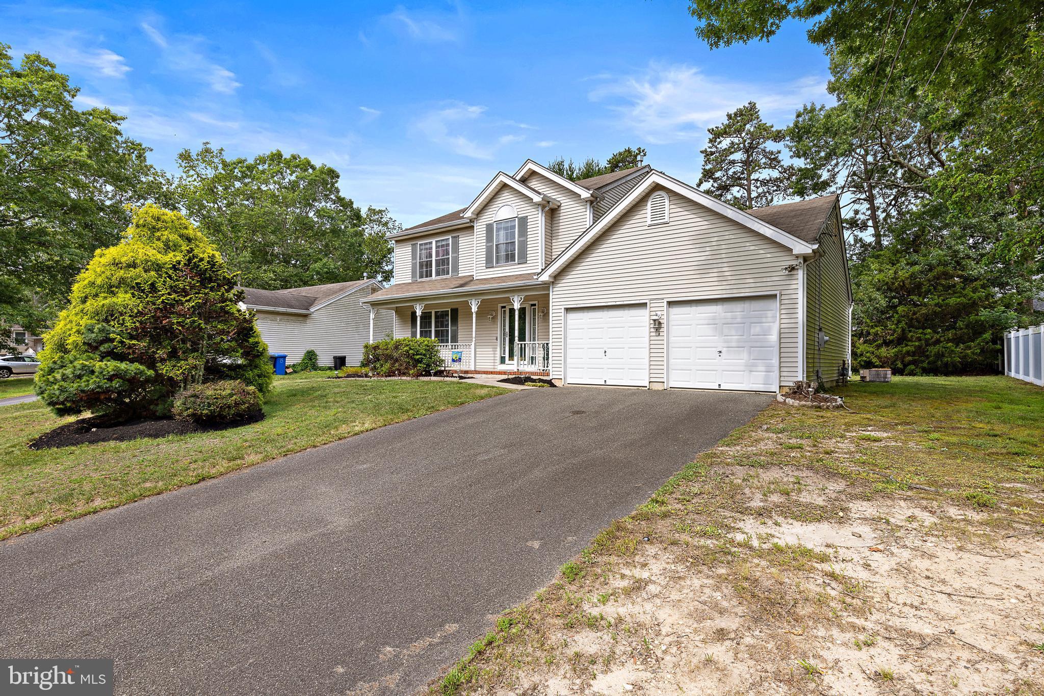 249 Topside Road Manahawkin, NJ 08050 - Photo 4 of 49 a front view of a house with a garden and yard