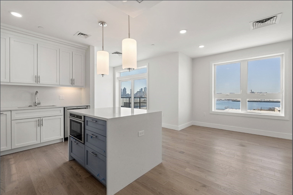 a kitchen with cabinets and wooden floor