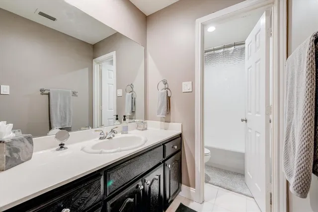 a bathroom with a sink a mirror and a painting on the wall