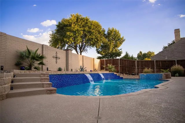 a view of backyard with swimming pool and seating space