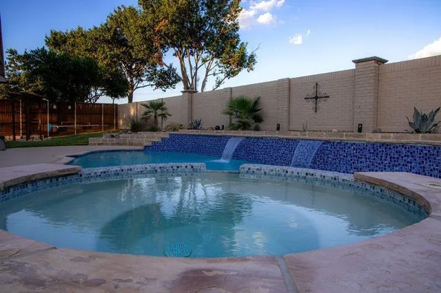 a view of a swimming pool with a patio and a yard