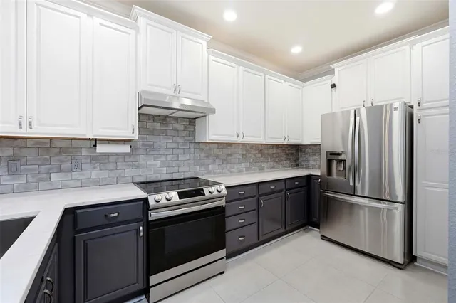 a kitchen with stainless steel appliances granite countertop a stove a refrigerator and a sink
