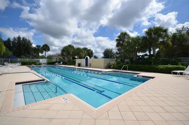 a view of swimming pool with lounge chair and dinning table under an umbrella