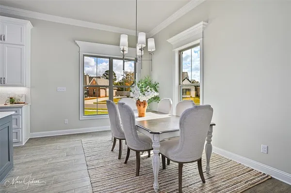 a dining room with furniture a chandelier and wooden floor
