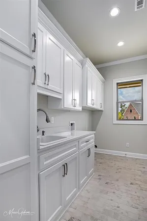 a kitchen with white cabinets and sink