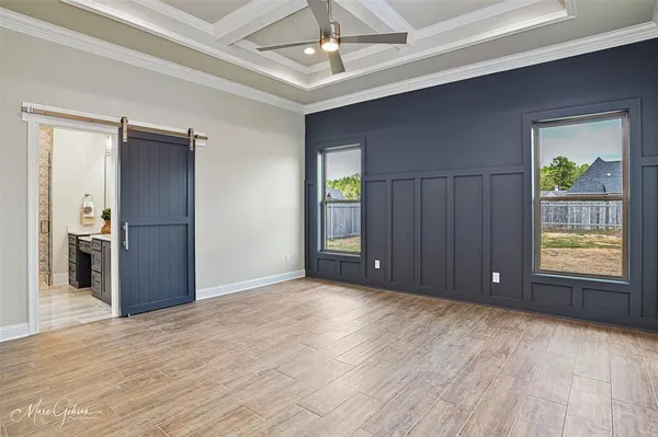 a view of an empty room with window and wooden floor