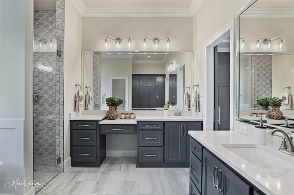 a bathroom with a granite countertop double vanity sink and mirror