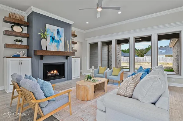 a living room with furniture a large window and a fireplace