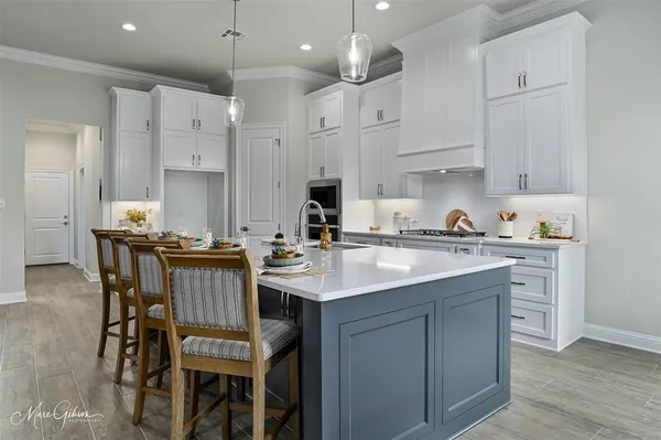 a kitchen with granite countertop a sink stove and white cabinets