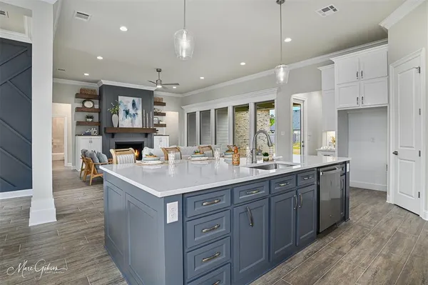 a kitchen with kitchen island a sink and a stove with wooden floor