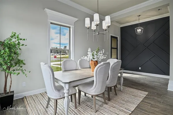 a view of a dining room with furniture wooden floor and chandelier