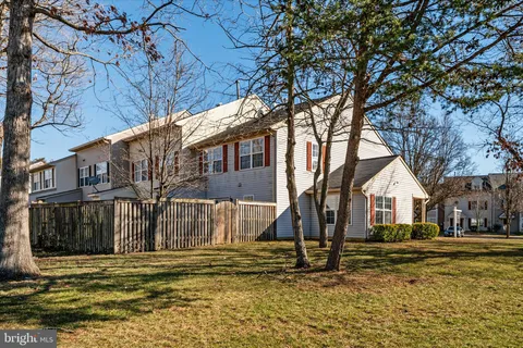 a view of a house with a yard and large tree