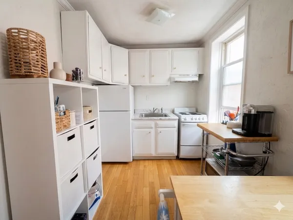 a kitchen with white cabinets and white appliances