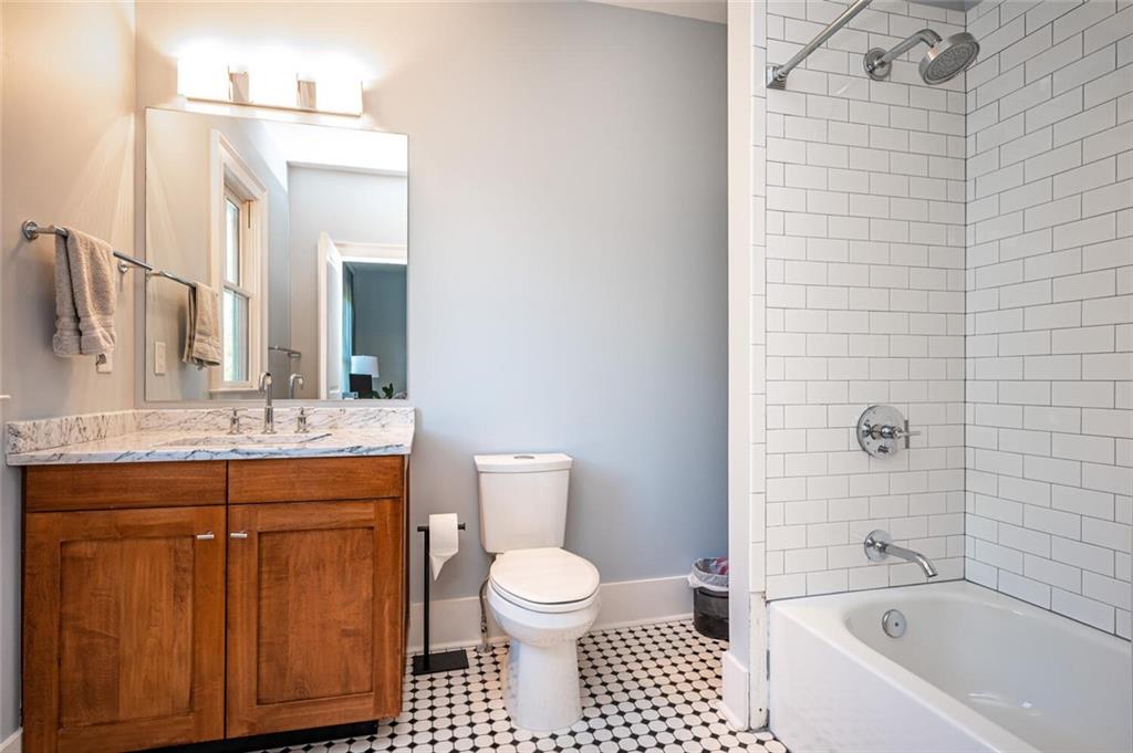 123 Ansley Street Decatur, GA 30030 - Photo 42 of 61 a bathroom with a granite countertop toilet a sink and a bathtub