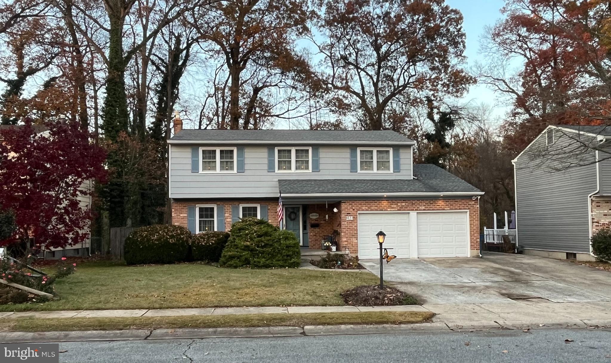 a front view of a house with garage and trees