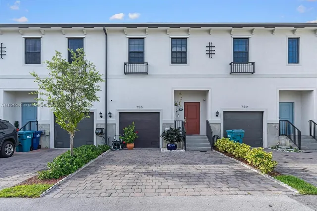 a front view of a house with a yard and a garage