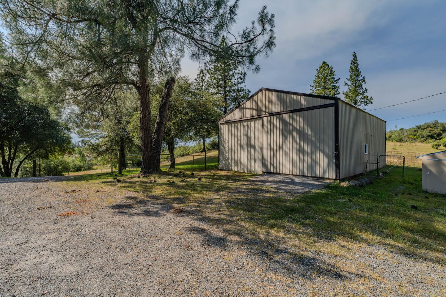 6216 Trout Lane Mountain Ranch, CA 95246 - Photo 20 of 39 a backyard of a house with lots of green space and wooden fence