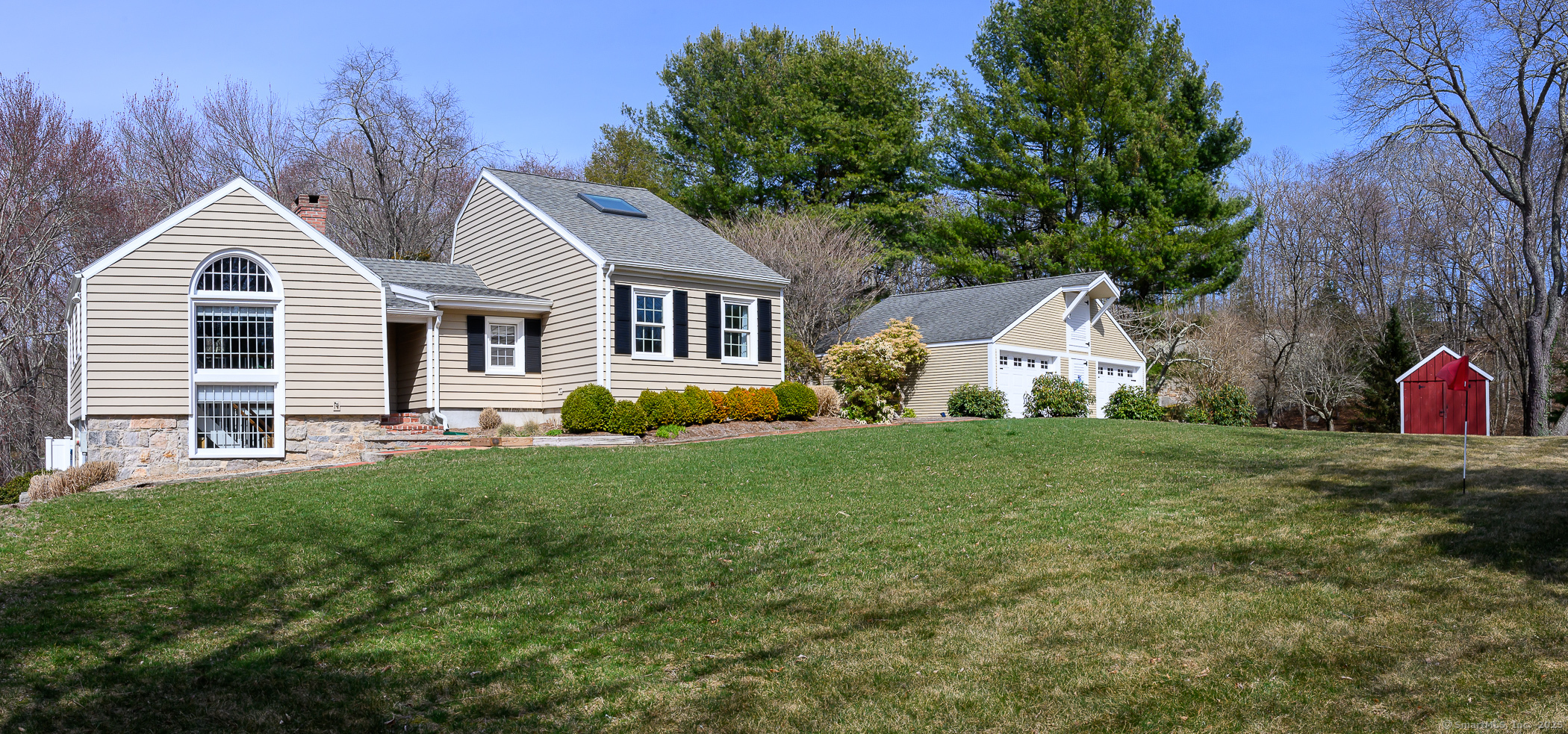 a front view of a house with a yard and trees