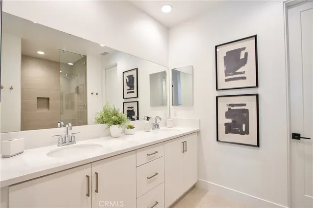 a bathroom with a double vanity sink a mirror and a shower