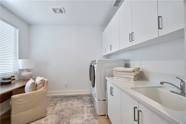a utility room with sink dryer and washer