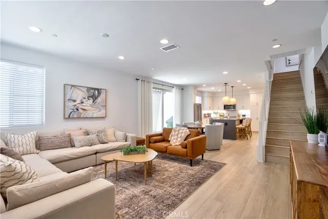 a kitchen with stainless steel appliances granite countertop a sink a stove a refrigerator cabinets and chairs