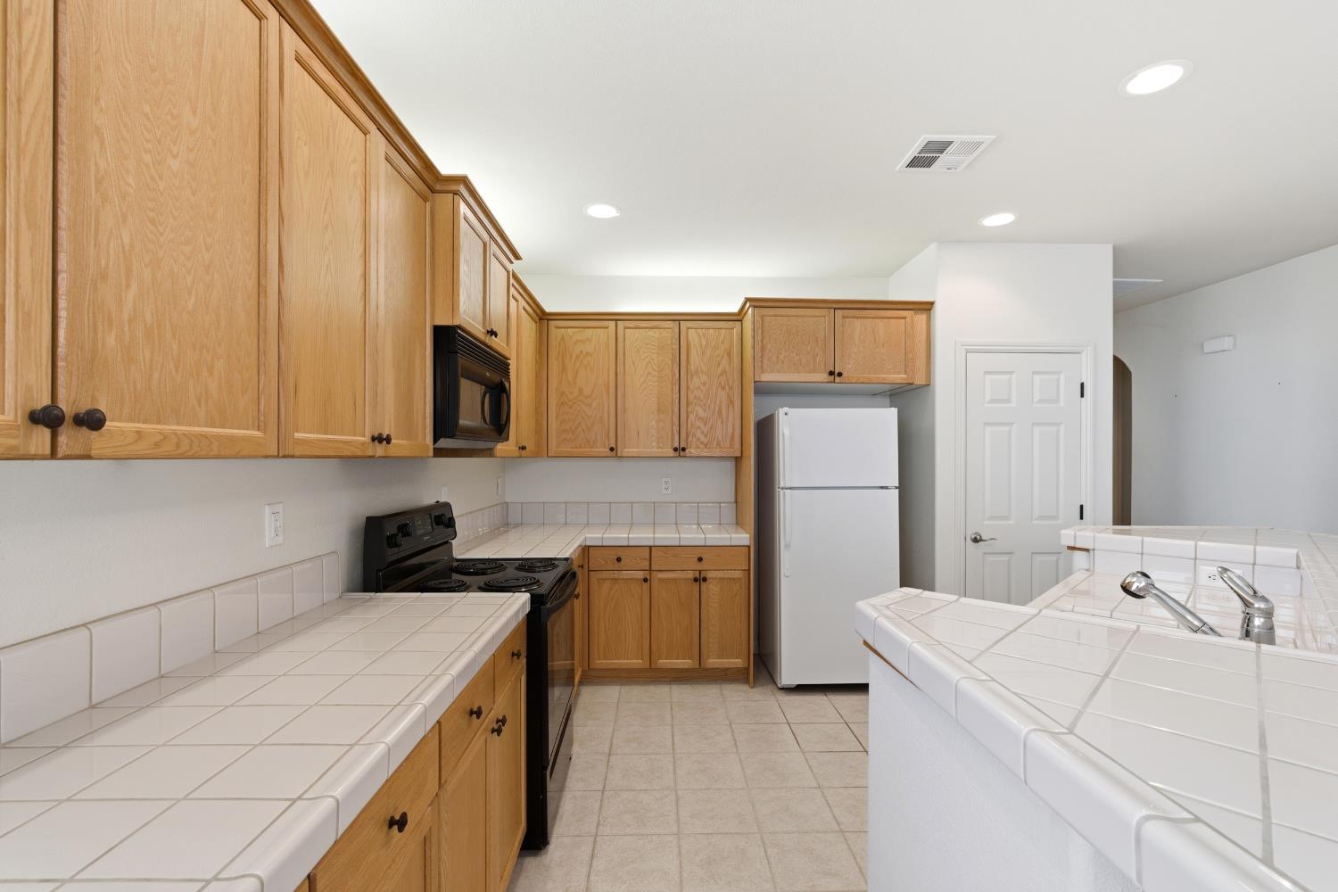 2450 Como Corte Chowchilla, CA 93610 - Photo 14 of 42 a kitchen that has a sink and a stove in it