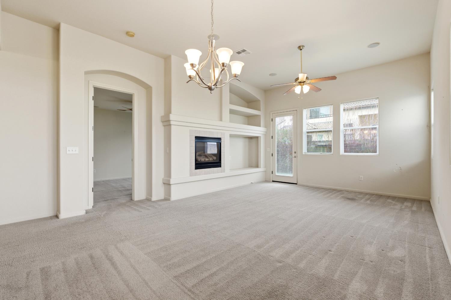 2450 Como Corte Chowchilla, CA 93610 - Photo 7 of 42 a view of an empty room with a fireplace and a window