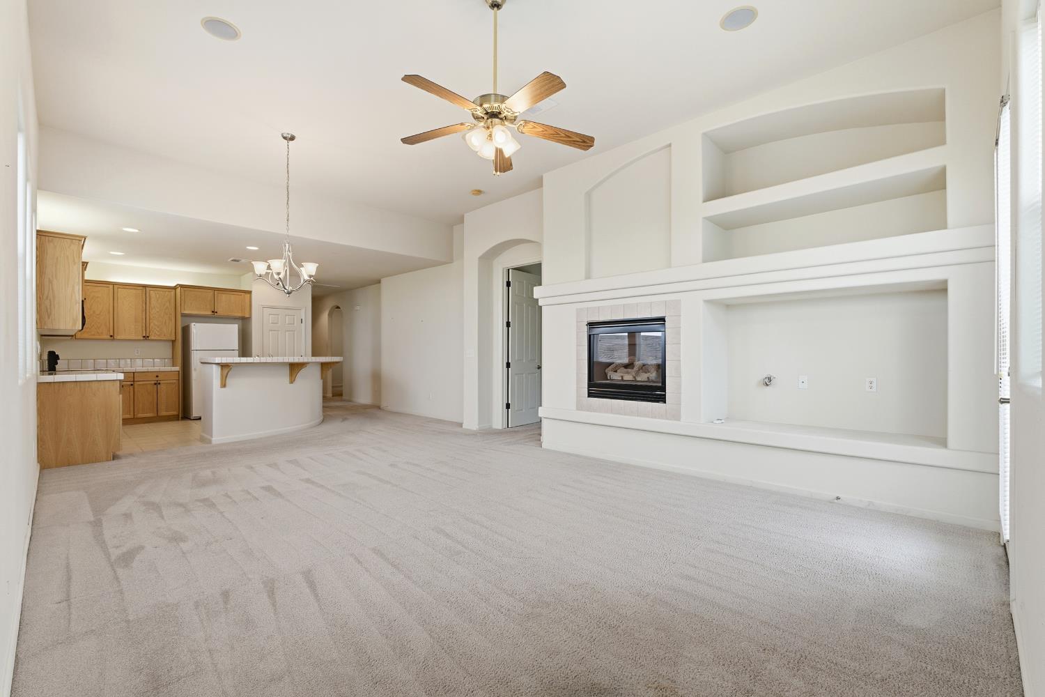 2450 Como Corte Chowchilla, CA 93610 - Photo 8 of 42 a view of a kitchen with furniture and a ceiling fan