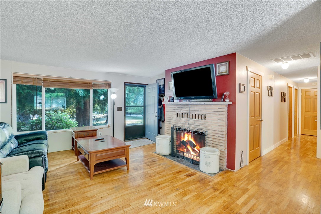 16619 192nd Avenue Southeast Renton, WA 98058 - Photo 4 of 37 a living room with furniture a flat screen tv and a fireplace
