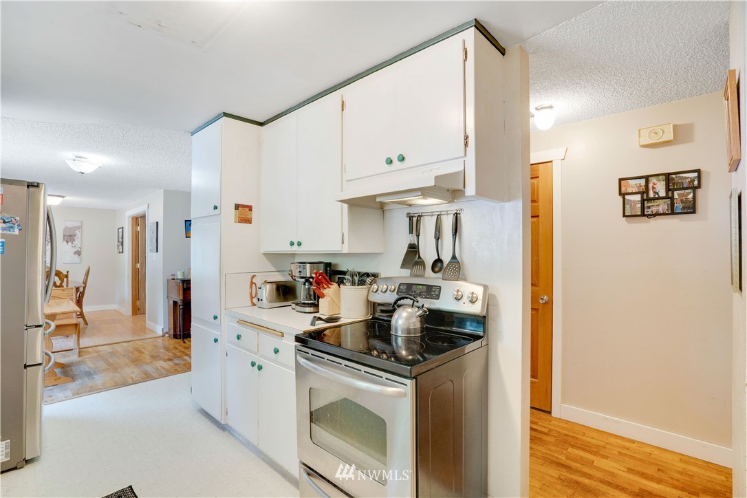 16619 192nd Avenue Southeast Renton, WA 98058 - Photo 6 of 37 a kitchen with stainless steel appliances granite countertop a stove a sink and a refrigerator