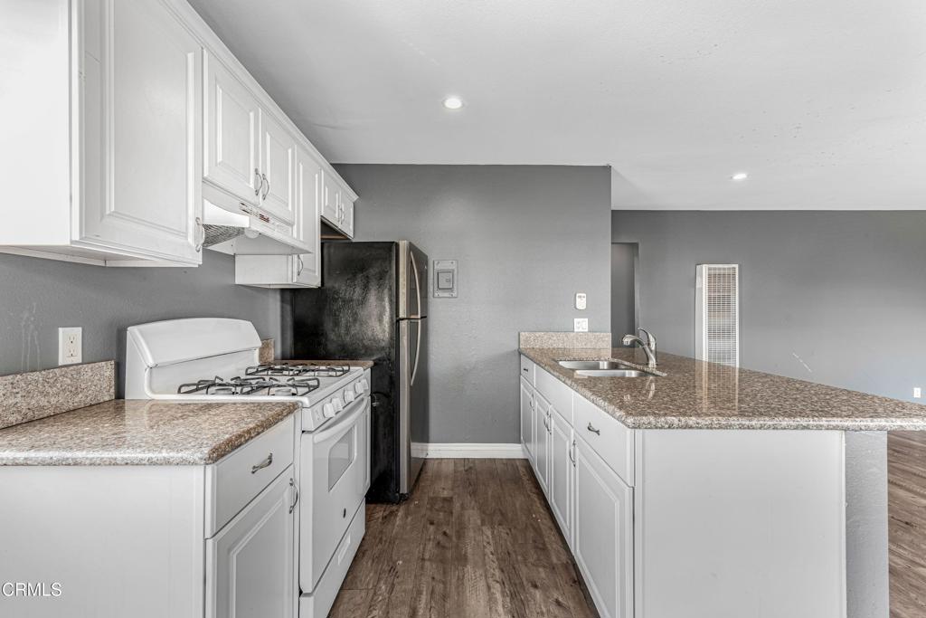 1920 North H Street, Unit 233 Oxnard, CA 93036 - Photo 7 of 26 a kitchen with stainless steel appliances granite countertop a sink stove and refrigerator