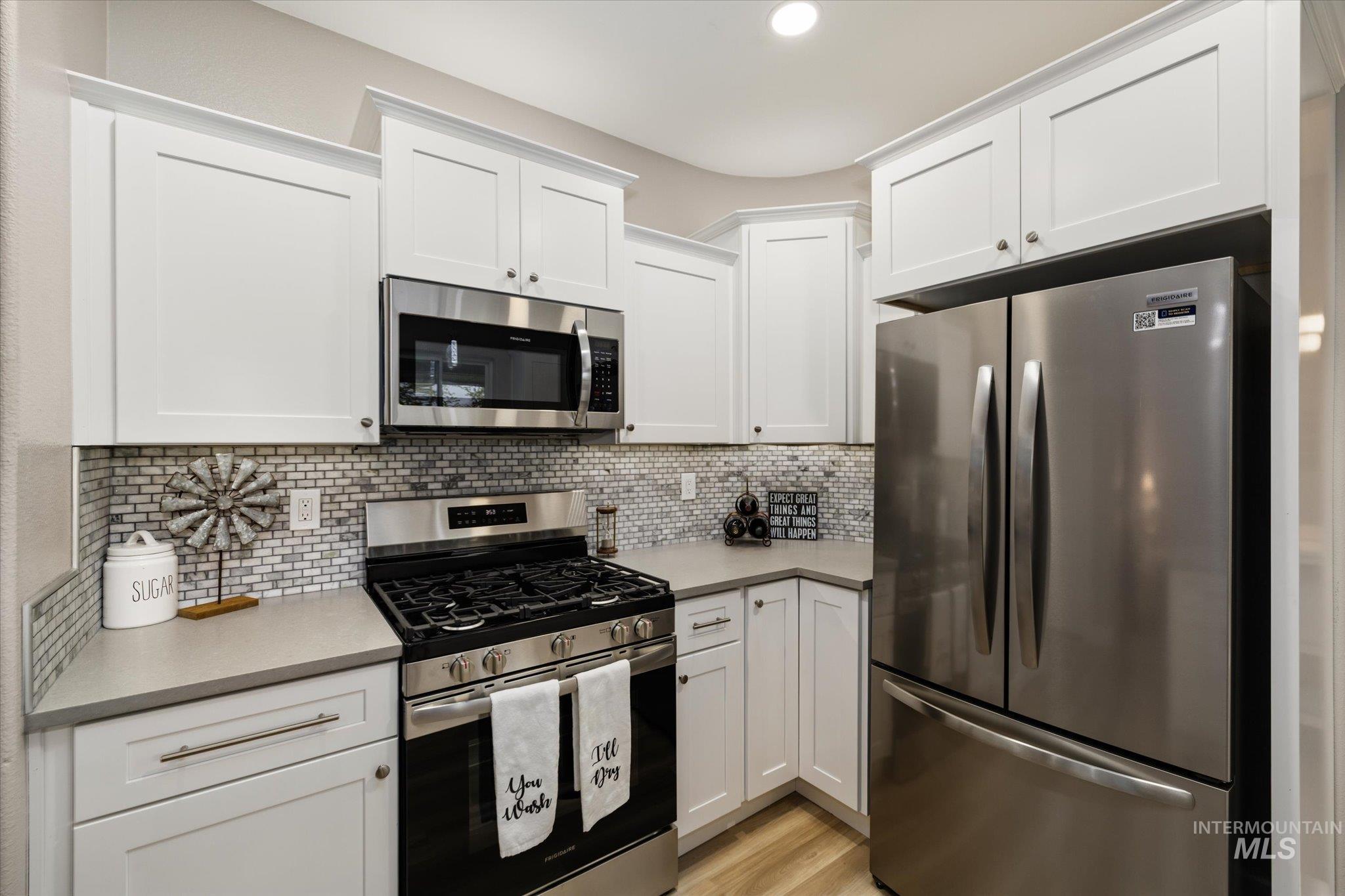 2250 North Amethyst Avenue Meridian, ID 83646 - Photo 18 of 50 Kitchen with stainless steel appliances, white cabinets, tasteful backsplash, light wood-type flooring, and recessed lighting