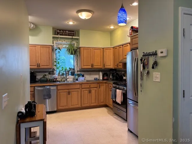 a kitchen with stainless steel appliances granite countertop a refrigerator sink and stove