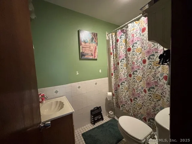a bathroom with a toilet sink and shower curtain