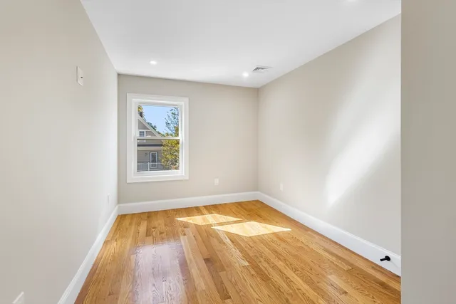 a view of a room with wooden floor and window